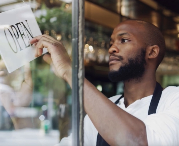 Image of a store owner flipping the open/closed sign